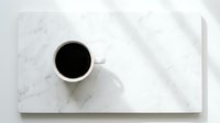 White coffee cup with black coffee on marble cutting board with natural lighting and shadows for kitchen and lifestyle concepts.