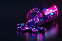 Medical capsules spilling from glass bottle in neon pink and blue lighting against dark background, creating futuristic pharmaceutical atmosphere.
