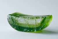 Fresh aloe vera gel slice with transparent texture and natural green color on white background, showing moisturizing properties for skincare and cosmetic use.