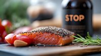 Fresh raw salmon fillet with black pepper and herbs on dark stone board, selective focus. Red fish steak ready for cooking, with rosemary garnish.