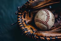 Worn leather baseball glove with weathered baseball nestled inside, showing detailed stitching and rich brown patina against dark background. Sports equipment macro.