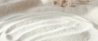 Smooth sand waves with dried seaweed on beach, zen garden aesthetic for relaxation and wellness content.