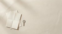 Blank white notebooks with vintage key on neutral beige background, flat lay composition for stationery, education, and creative design projects.
