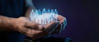 Male hands holding glowing holographic group of people figures representing team management, leadership and human resources in business technology concept.