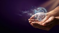 Open hand holding glowing digital currency symbol with sparkling light effects and particles dispersing into dark background for fintech and blockchain concepts.