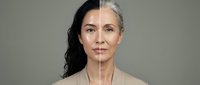 Middle-aged Asian woman showing aging process with half young half mature face split comparison for skincare beauty treatment anti-aging concept.