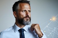 Confident mature businessman with beard contemplating next strategic move against technology network background, representing leadership and innovation in digital age.