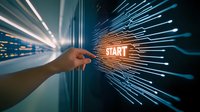 Human hand pointing at glowing start button with radiating digital lines in blue technological background, representing digital transformation and innovation.