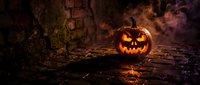 Carved jack-o-lantern pumpkin glowing with orange light in dark abandoned basement with brick walls and fog, creating spooky atmosphere for seasonal decorations and holiday celebrations.