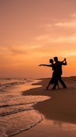 Romantic couple dancing on beach at sunset with golden sky and ocean waves creating intimate silhouette moment for love and relationship concepts.