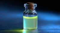 Glowing yellow-green luminescent liquid in glass bottle with cork stopper against dark blue background, creating mysterious scientific atmosphere.