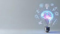 Light bulb with glowing brain and innovation icons on gray background representing creativity, artificial intelligence and business solutions.