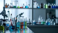 Modern laboratory with microscope and colorful chemical solutions in glassware on research table. Scientific equipment for experiments and analysis.