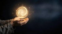 Businessman hands holding glowing golden energy spiral with magical particles floating above palms against dark background for business innovation concepts.