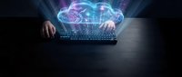 Hands typing on laptop with glowing cloud computing hologram above keyboard representing digital technology and data storage solutions for business.