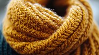 Cozy golden yellow knitted scarf with chunky cable pattern texture, warm winter accessory for cold weather fashion and seasonal comfort wear.