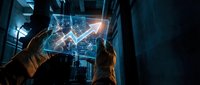 Business professionals analyzing holographic financial data charts and graphs in modern office environment for strategic planning and decision making.