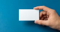 Hand holding blank white business card on blue background for corporate identity and branding mockup presentations.