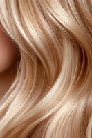 Close-up of flowing blonde hair with soft waves and highlights showing natural movement and shine, suitable for beauty and hair care advertising campaigns.