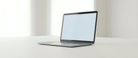 Modern laptop computer with blank white screen on clean white desk in minimalist office workspace for business presentations and mockup designs.
