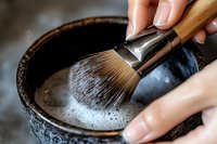 Traditional Japanese tea ceremony preparation with bamboo whisk creating frothy matcha in ceramic bowl, cultural ritual and mindfulness practice.