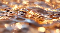 Glowing golden water waves with sparkling light effects and bokeh, abstract liquid surface with shimmering reflections in warm sunset colors. Artistic macro photography.
