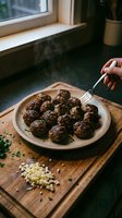 Freshly cooked meatballs on wooden plate with steam rising, hand holding fork ready to eat homemade comfort food in rustic kitchen setting.
