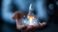 Glowing rocket launching from open palm against blue background with magical sparkles and light effects, symbolizing business startup and innovation success.