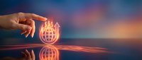 Hand holding glowing globe icon with orange light effect, representing global connectivity, international business, and worldwide digital communication network technology.
