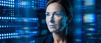 Young Caucasian woman with facial recognition grid overlay in futuristic digital technology environment with blue data visualization screens.