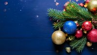 Festive Christmas decoration with colorful ornaments and pine branches on dark blue wooden background for holiday greeting cards.