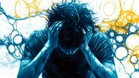 Young man holding head in despair against abstract blue and yellow bubble background, expressing emotional stress, anxiety and mental health challenges.
