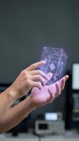 Hand holding glowing purple geometric wireframe cube with connected nodes and lines, representing digital technology, data visualization, artificial intelligence, and innovation in modern computing environment.