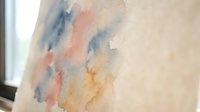 Abstract watercolor painting with soft blue orange and yellow brushstrokes on textured paper creating artistic background for creative projects.