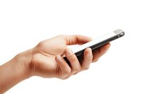 Female hands holding modern smartphone isolated on white background. Close up view of casual mobile device use showing natural grip and gestures.
