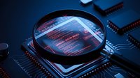 Magnifying glass examining computer circuit board with red security alert message, cybersecurity threat detection and digital forensics analysis concept.