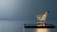 Glowing miniature shopping cart placed on smartphone against dark background, representing online shopping and e-commerce concepts.