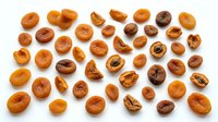 Fresh apricot halves arranged on white background showing natural fruit texture and golden orange color for healthy eating concepts.