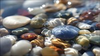 Smooth colorful pebbles underwater with clear rippling water, creating a tranquil natural scene for wellness and meditation backgrounds.
