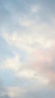 Soft pastel sky with fluffy white clouds in pink and blue hues creating dreamy atmosphere for backgrounds and romantic designs.