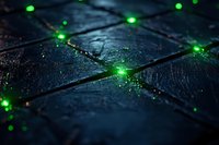 Glowing green particles scattered across dark wet stone tiles create mysterious atmospheric effect with selective focus and bokeh lights for fantasy backgrounds.