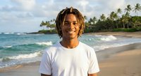 Young African American man with dreadlocks smiling on tropical beach at sunset. Ocean waves and palm trees create relaxing vacation atmosphere for lifestyle content.