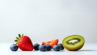 Fresh mixed berries and kiwi fruit arranged on white surface with copy space for healthy eating and nutrition concepts.