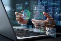 Hands emerging from laptop screen displaying holographic business analytics dashboards with charts, graphs and data visualization interface elements.
