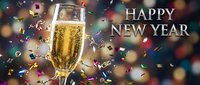 Champagne flute with sparkling wine surrounded by colorful confetti and bokeh lights, Happy New Year celebration greeting card.