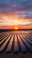 Solar panel farm at sunset with dramatic orange and golden sky, reflecting light across rows of photovoltaic cells for renewable energy and sustainable power generation.