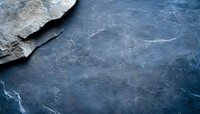 Dark blue stone texture with rough broken edge and natural cracks creating dramatic abstract background for luxury product presentation or design layouts.