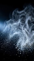 White powder or dust particles exploding and dispersing against dark background with blue lighting, suitable for cosmetics, flour, or chemical product advertising.