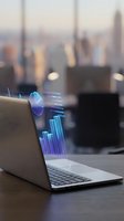 Laptop displaying holographic data visualization charts and graphs in modern office environment for business analytics and financial reporting presentations.