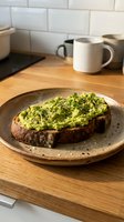 Avocado toast on sourdough bread with microgreens and black pepper served on ceramic plate in modern kitchen setting for healthy breakfast concept.